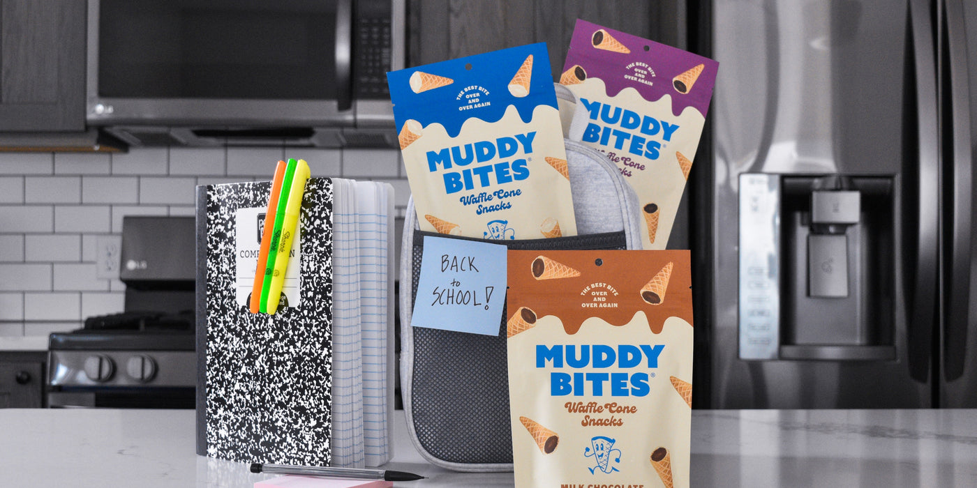 Muddy Bites in a lunch bag with school supplies on a kitchen counter